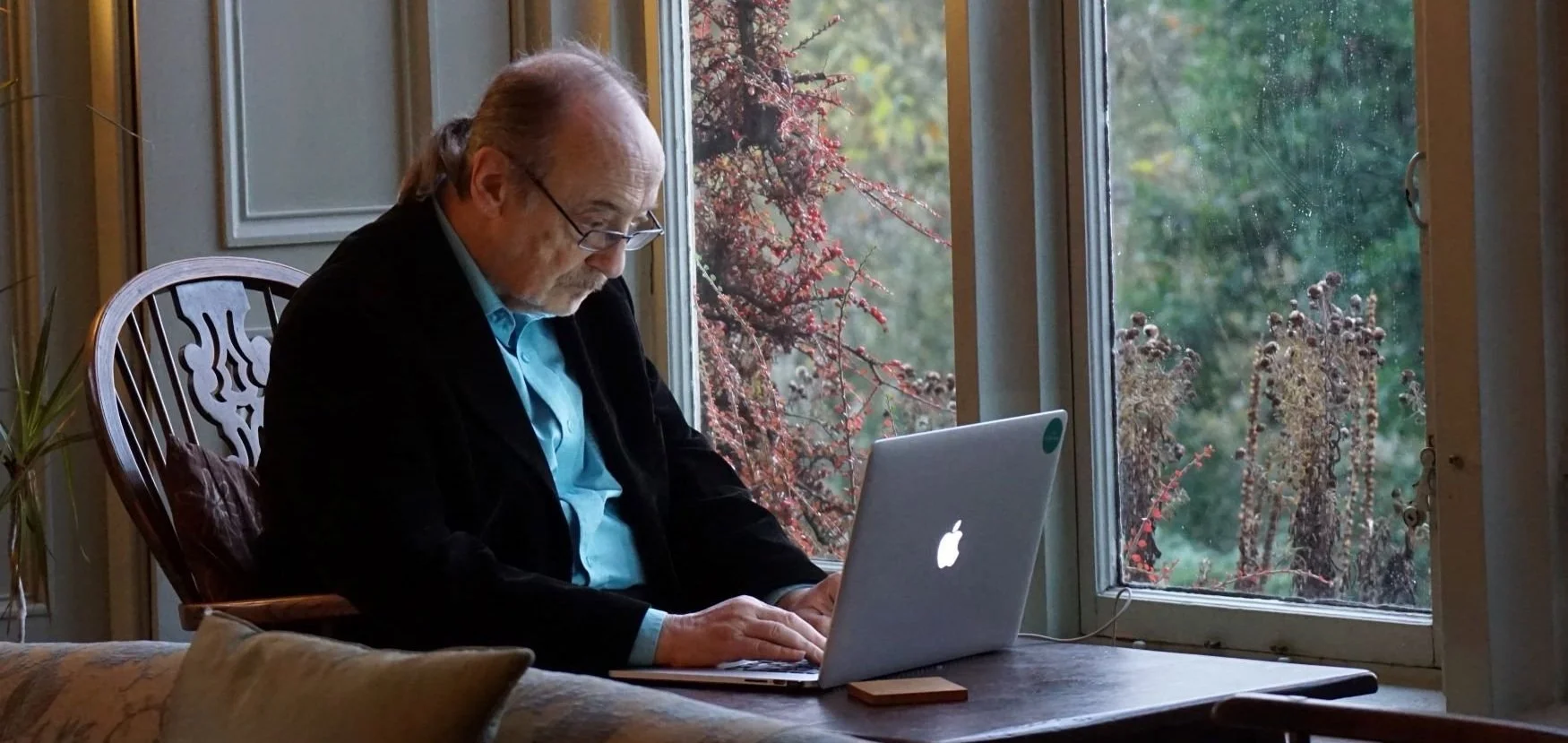 Thoughtful older woman at a desk with a notebook